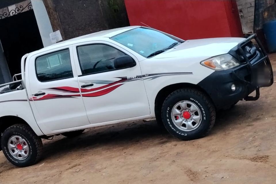 Toyota Hilux Double Cab blanc, vue de profil, disponible à la location avec chauffeur à Douala